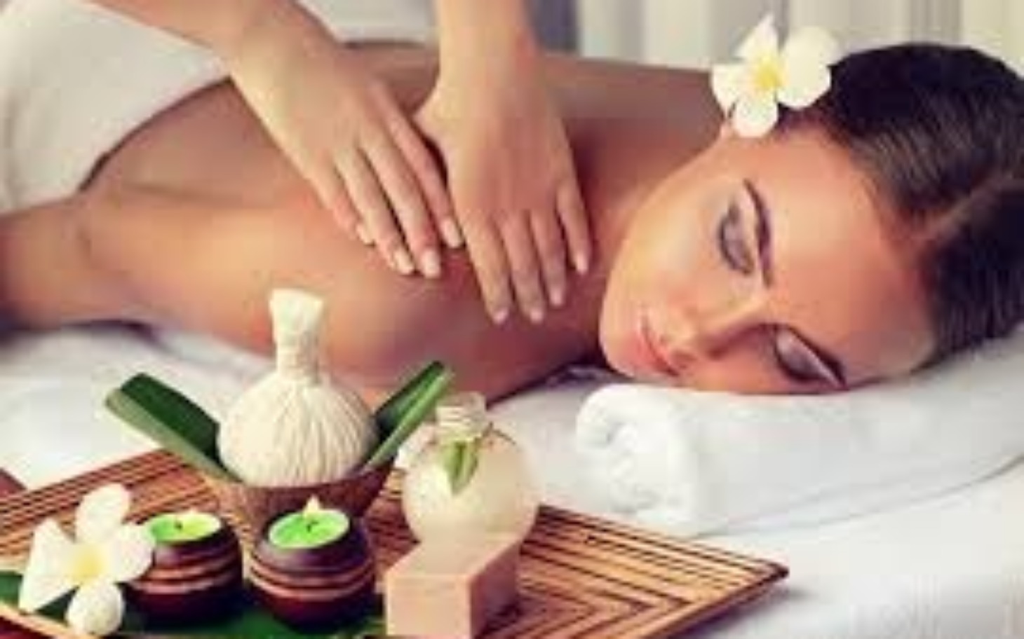 
        Kobieta na masażu, relaksująca się w spa z kwiatem we włosach.
    