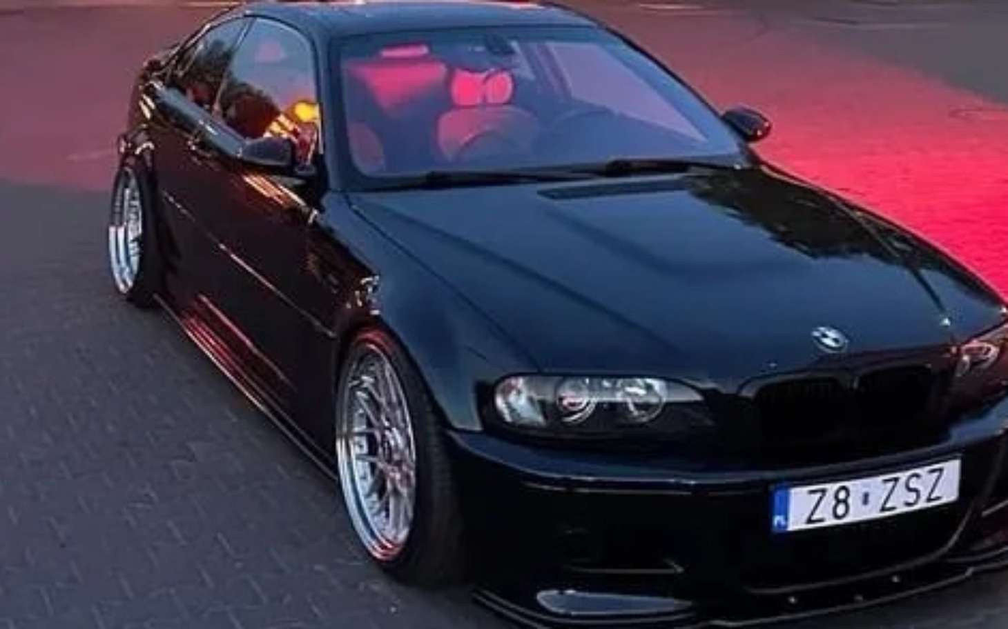 
        Czarny samochód sportowy, widok z boku, elegancki design.
    