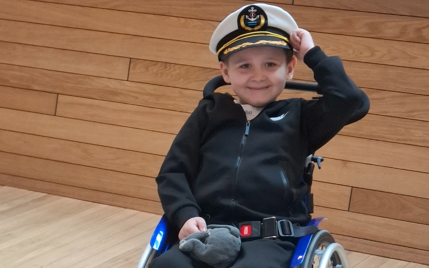 
        Chłopiec w wózku, przebrany za kapitana.
    