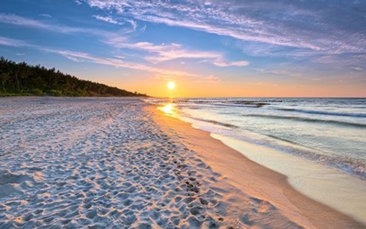 
        Plaża o zachodzie słońca, z falami i piaskiem.
    