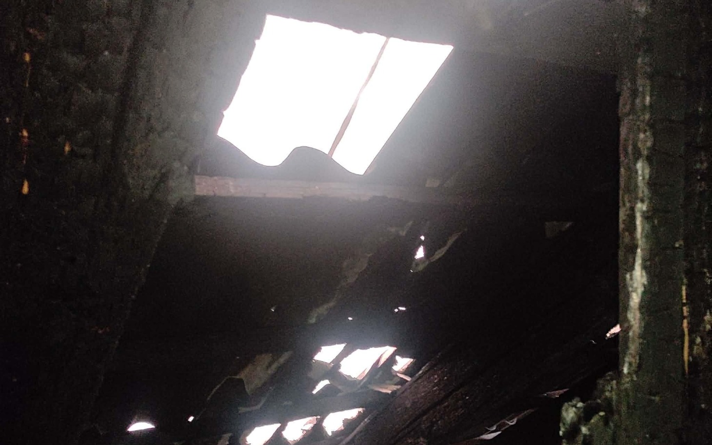 
        Zniszczony dach po pożarze, widoczne uszkodzenia.
    