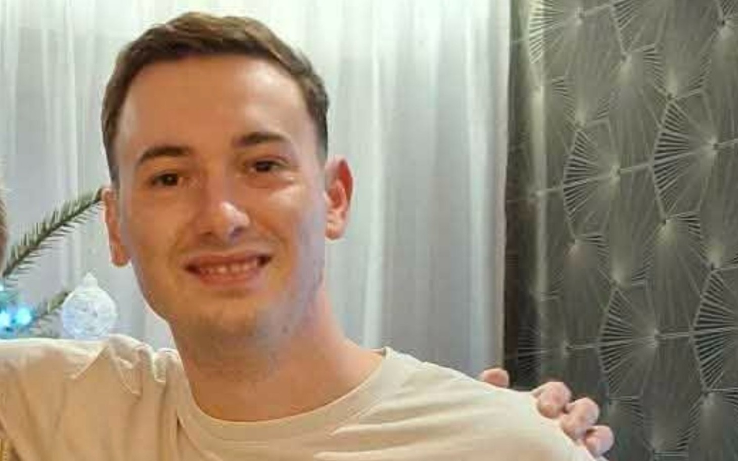 
        Mężczyzna uśmiechający się w przytulnym wnętrzu.
    