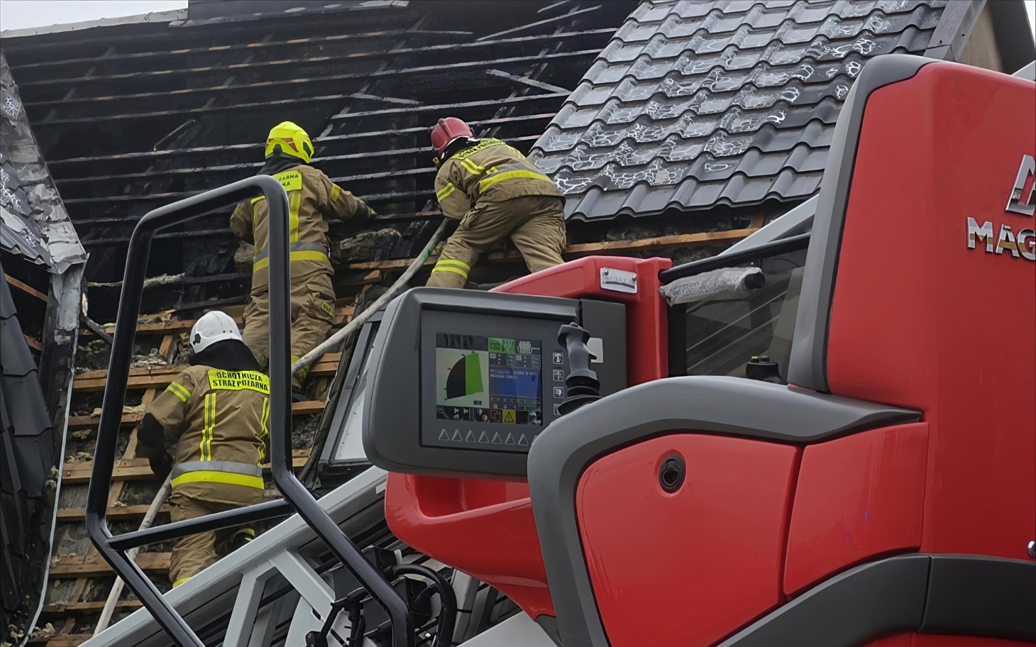 
        Strażacy gaszący pożar na dachu budynku.
    
