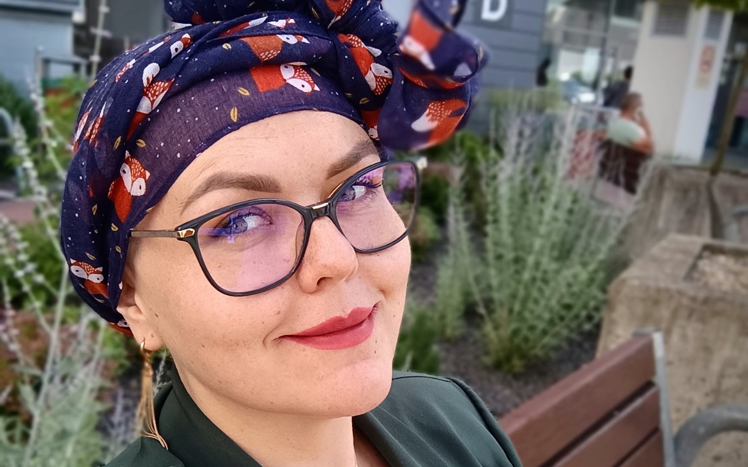 
        Kobieta w turbanie, uśmiechająca się do kamery.
    