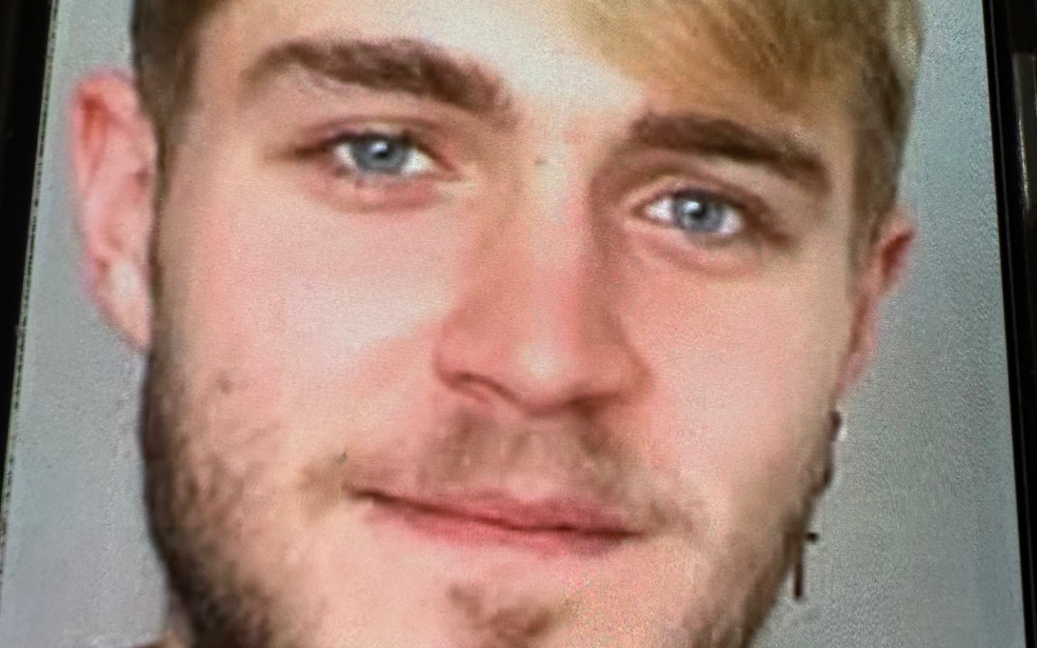 
        Młody mężczyzna z uśmiechem, z bliskim ujęciem twarzy.
    