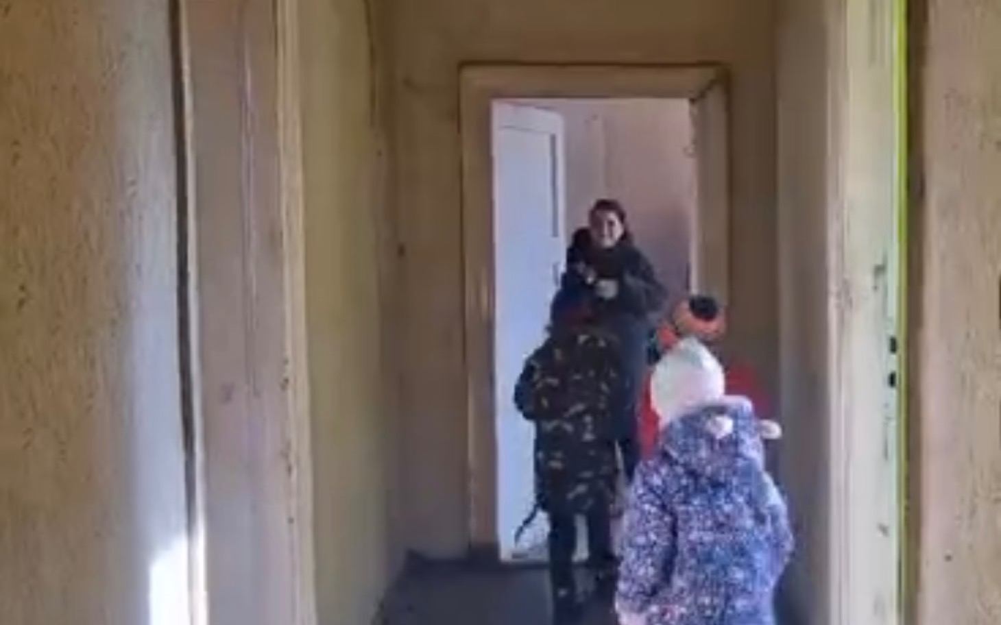 
        Dzieci w kamizelkach przechodzą przez korytarz w budynku.
    