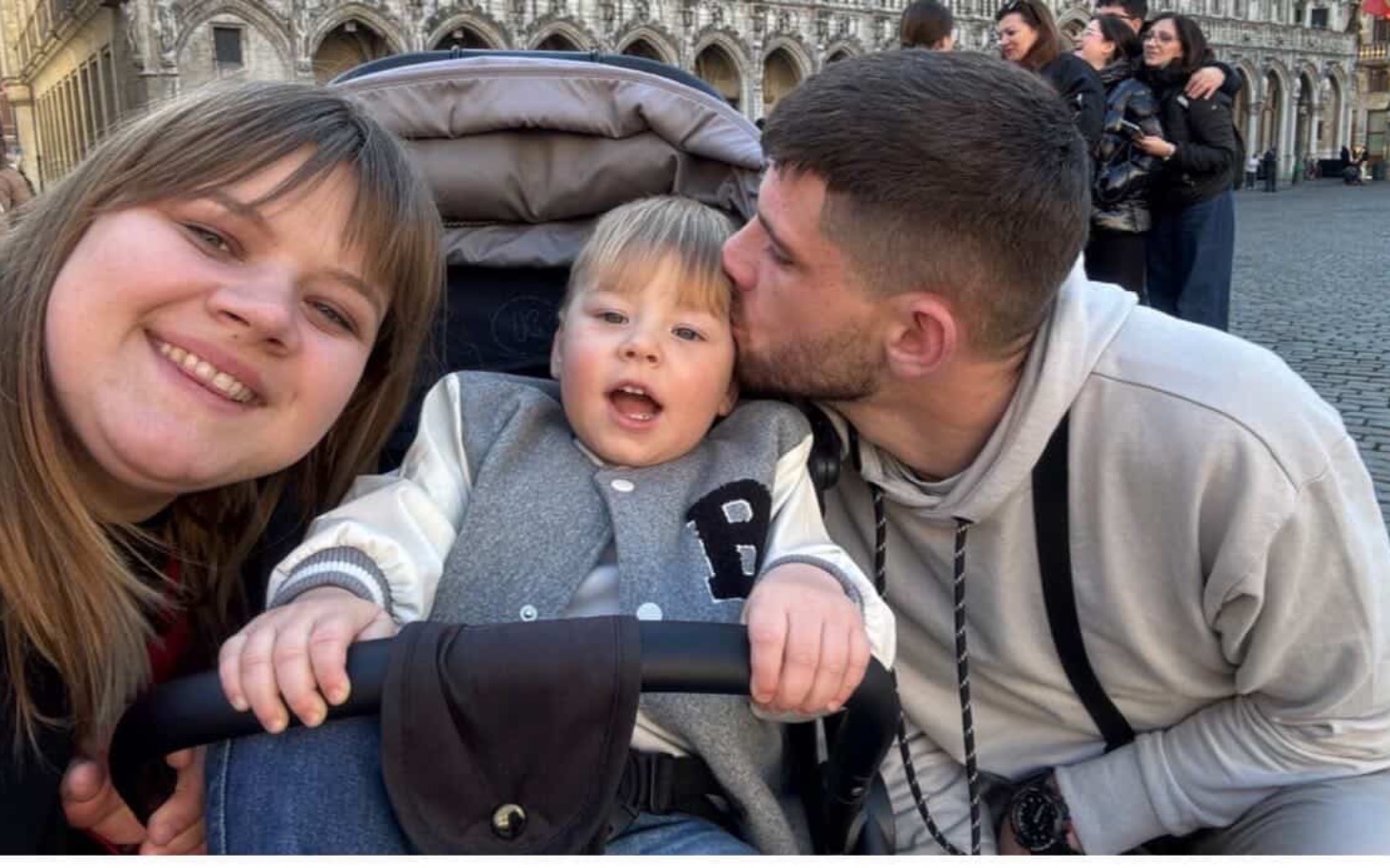 
        Rodzinne selfie z uśmiechami na tle miasta.
    