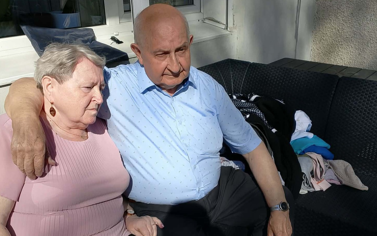 
        Starsza para siedzi razem na kanapie, wyrażając bliskość i wsparcie.
    