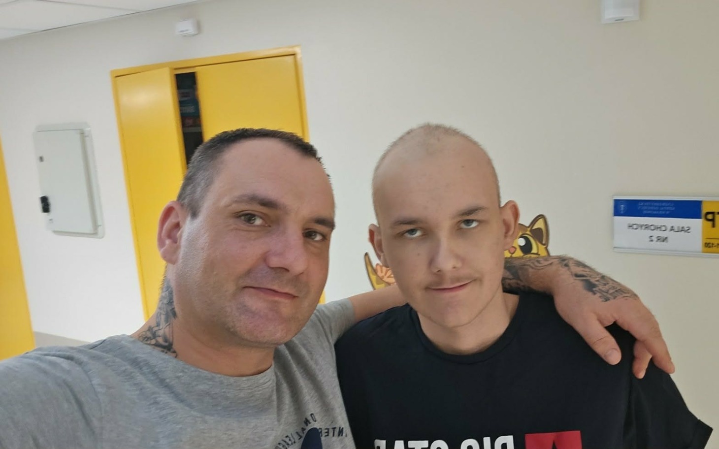 
        Mężczyzna z chłopcem w szpitalu, obaj uśmiechnięci.
    