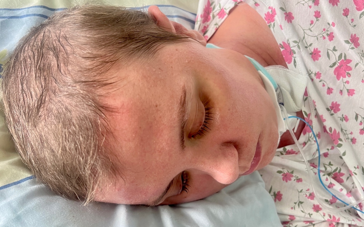 
        Kobieta leżąca w łóżku, z zamkniętymi oczami.
    