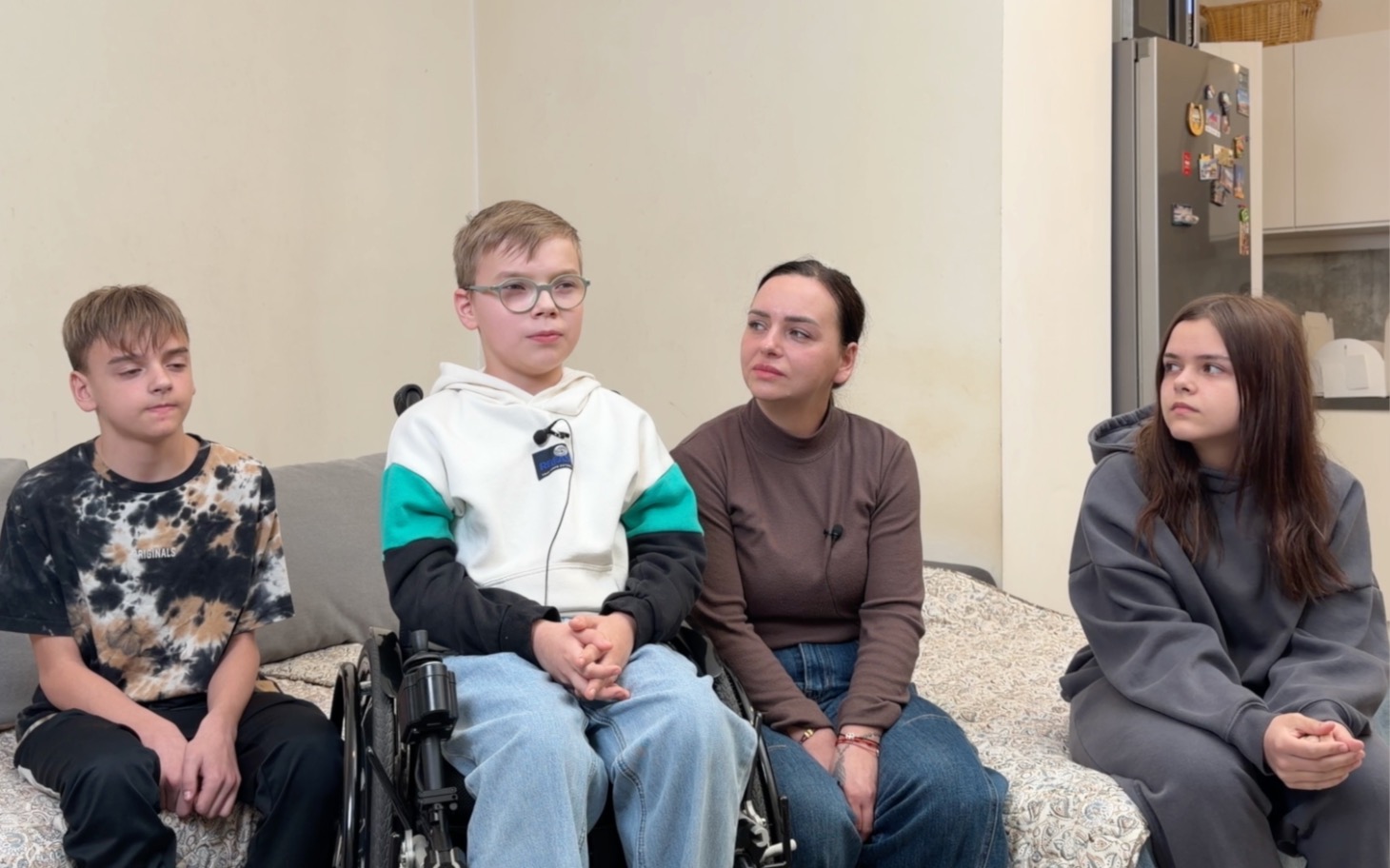 
        Czwórka dzieci i dorosła kobieta siedząca na łóżku.
    