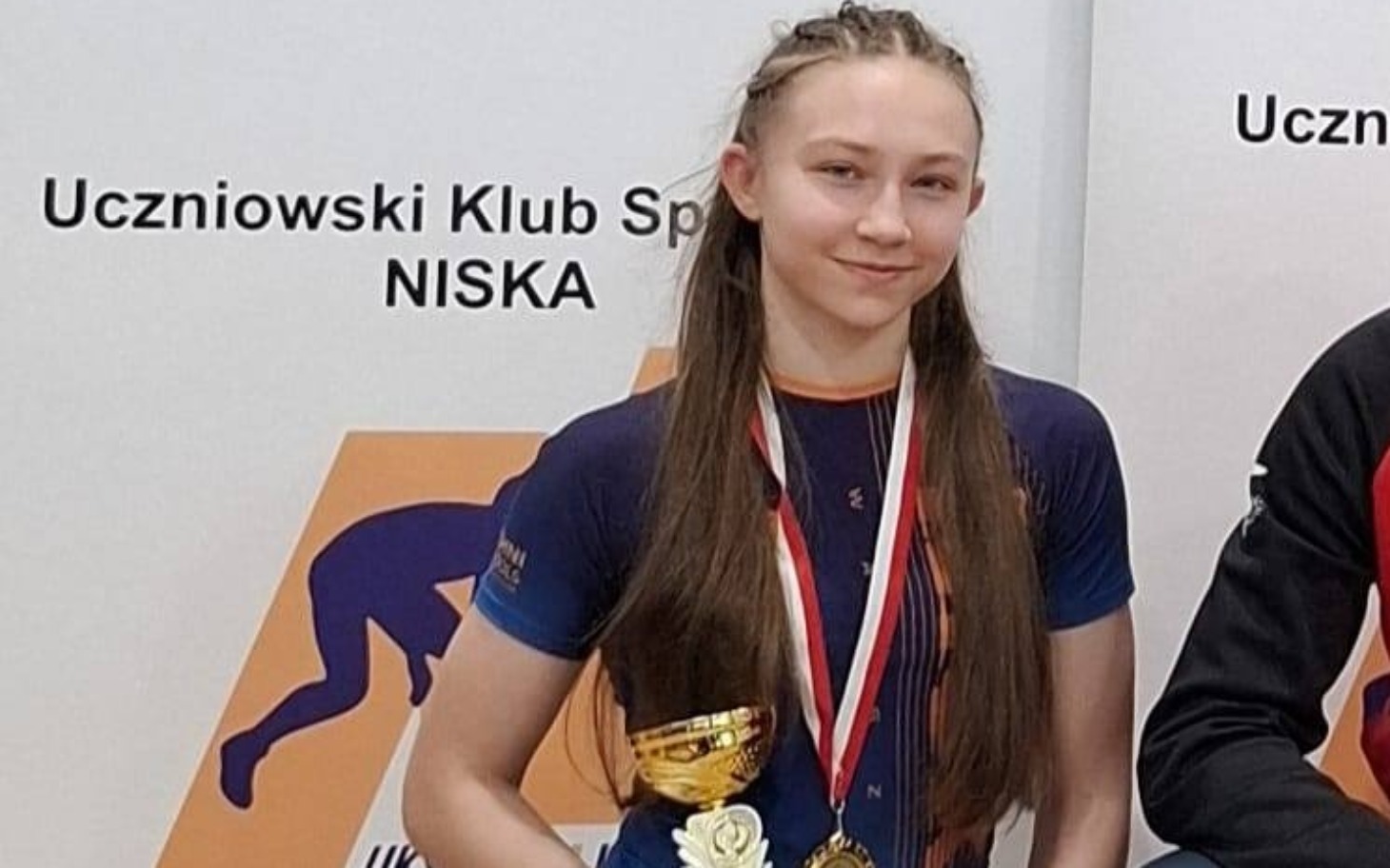 
        Młoda sportsmenka z medalami na zawodach.
    