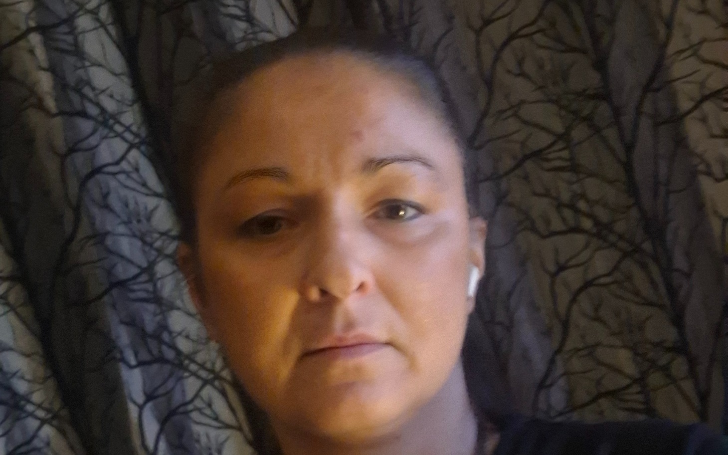 
        Portret kobiety w słuchawkach, z tłem zasłon.
    