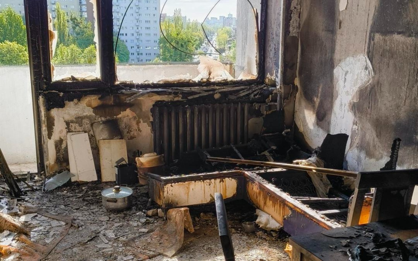 
        Zniszczone wnętrze po pożarze, z widokiem na zniszczone meble.
    