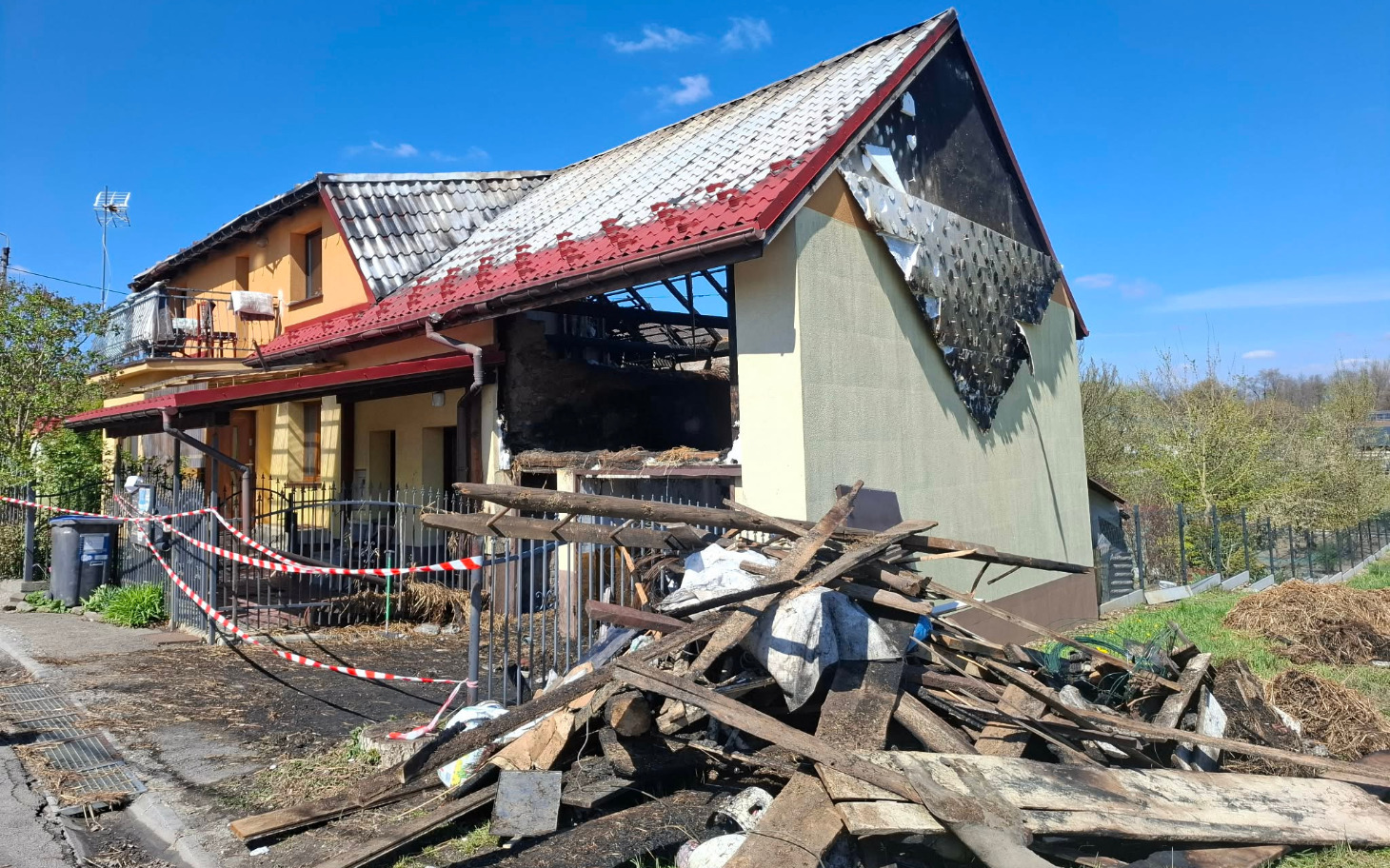 
        Zniszczony dom z uszkodzoną dachówką, otoczony gruzem.
    