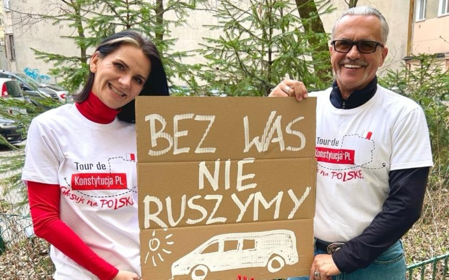 
        Dwoje ludzi trzymających plakat z hasłem o wspólnym działaniu.
    