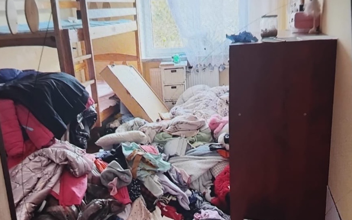 Zabałaganione wnętrze pokoju z ubraniami.