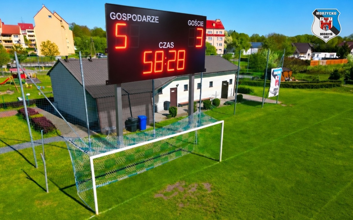 
        Boisko piłkarskie z tablicą wyników, gospodarze prowadzą 5:3.
    