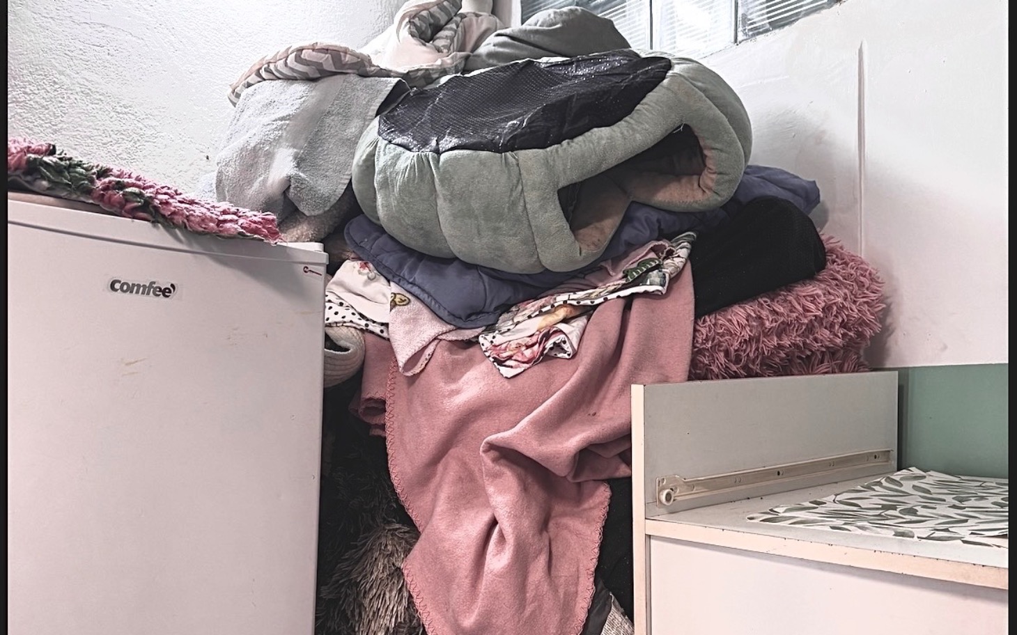 
        Stos koców i poduszek, tworzący przytulne miejsce.
    