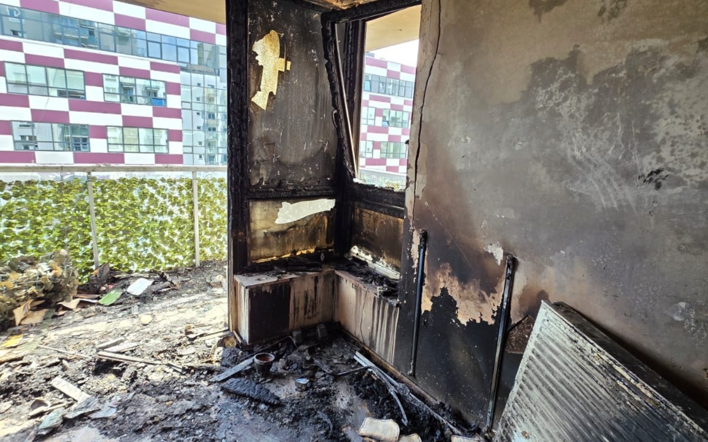 
        Zniszczone wnętrze mieszkania po pożarze, z czarnymi ścianami.
    