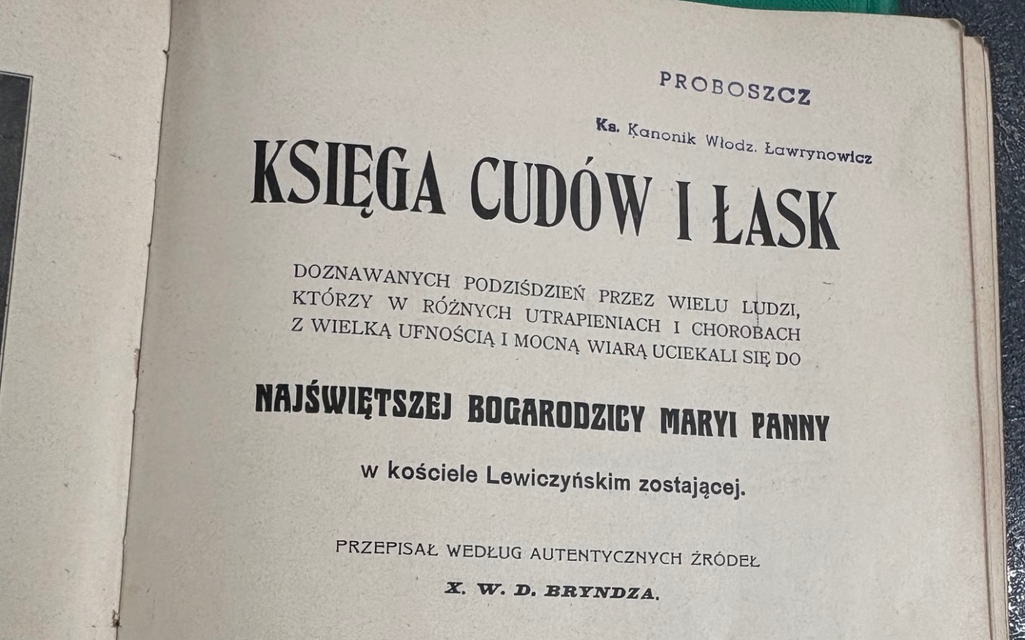 
        Stare tomy i dokumenty leżące na kartce z napisem KSIEGA CUDÓW I LASK.
    