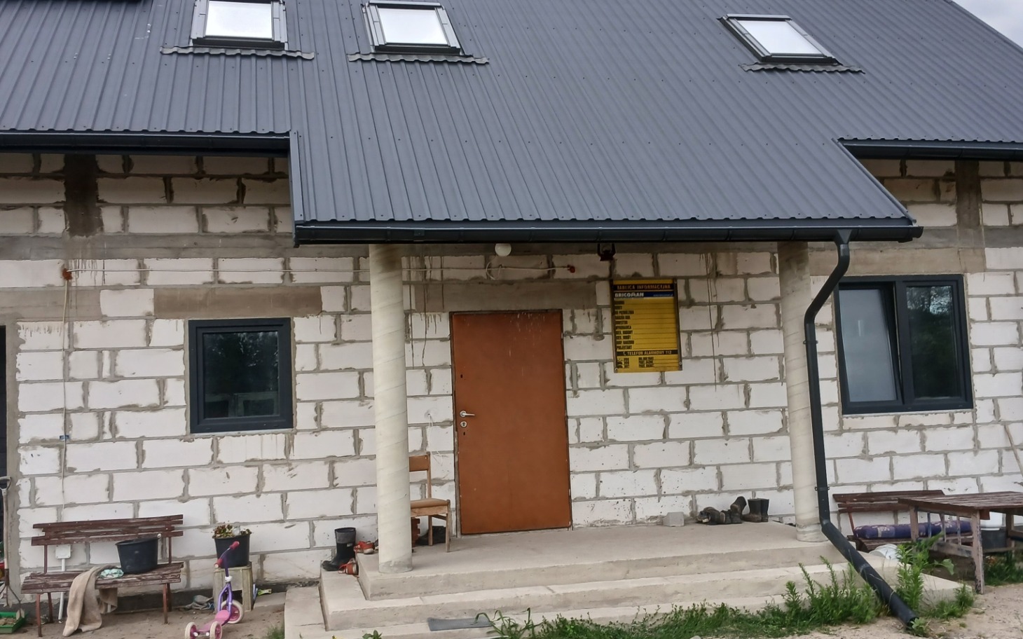 
        Zatrzymany dom jednorodzinny z metalowym dachem i wejściem
    