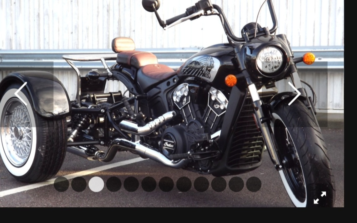 
        Piękny motocykl z czarną skórzaną kanapą i białymi kołami na parkingu.
    