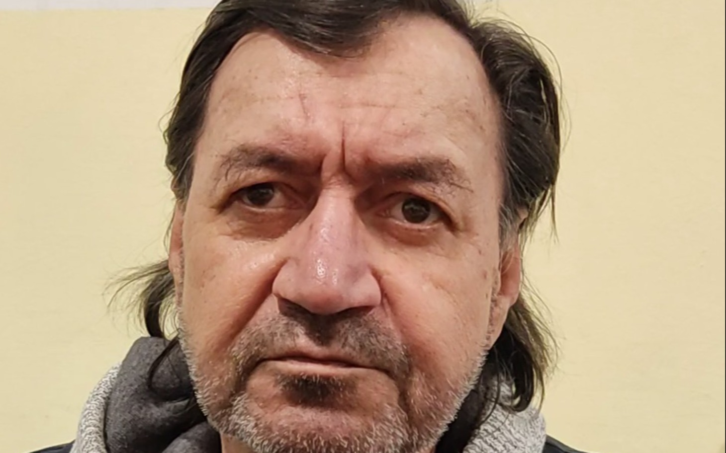
        Kociak czarny i brązowy w klatce, spojrzenie w kamerę
    