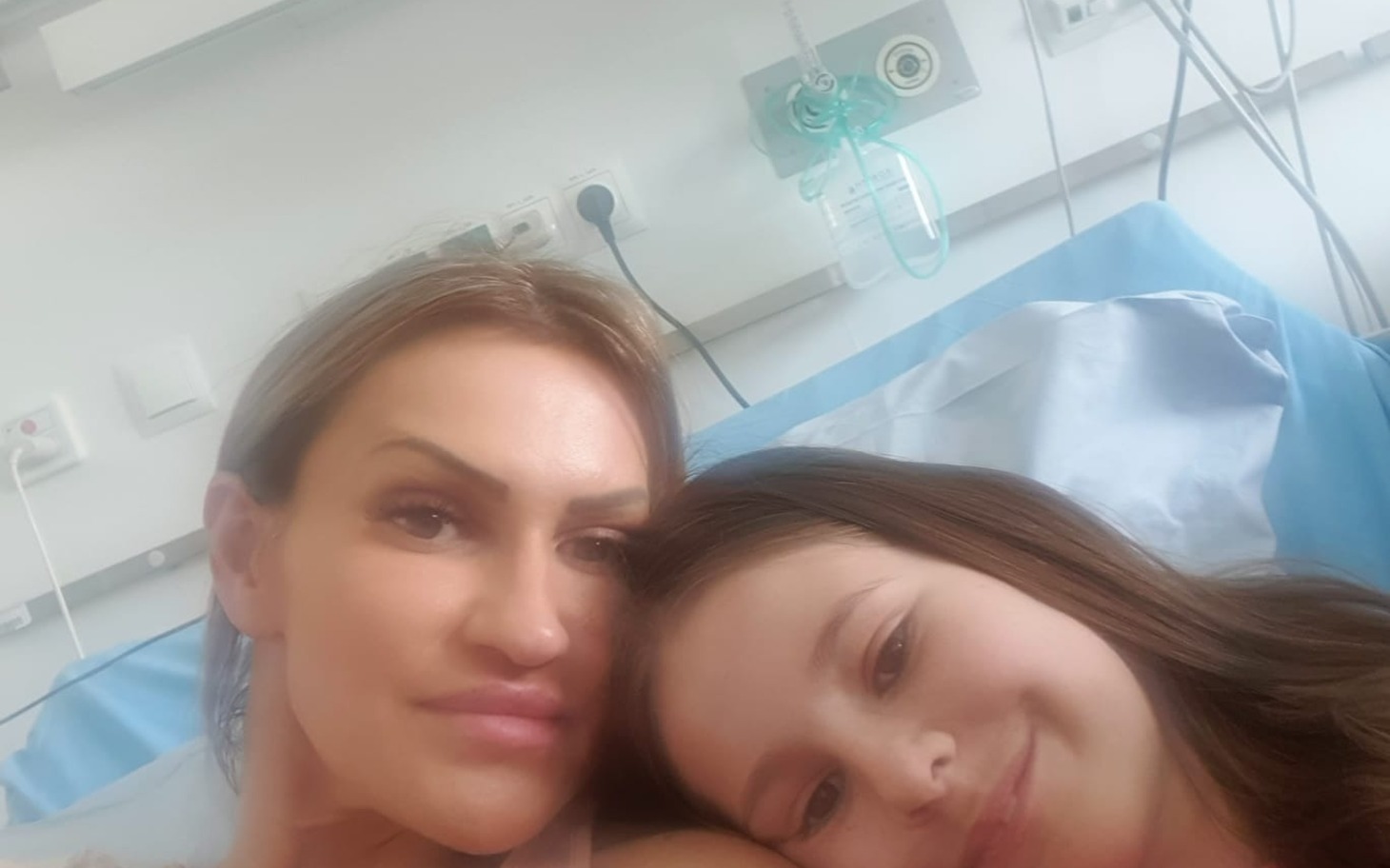 
        Dwie kobiety na oddziale szpitalnym, uśmiechnięte, na łóżku.
    