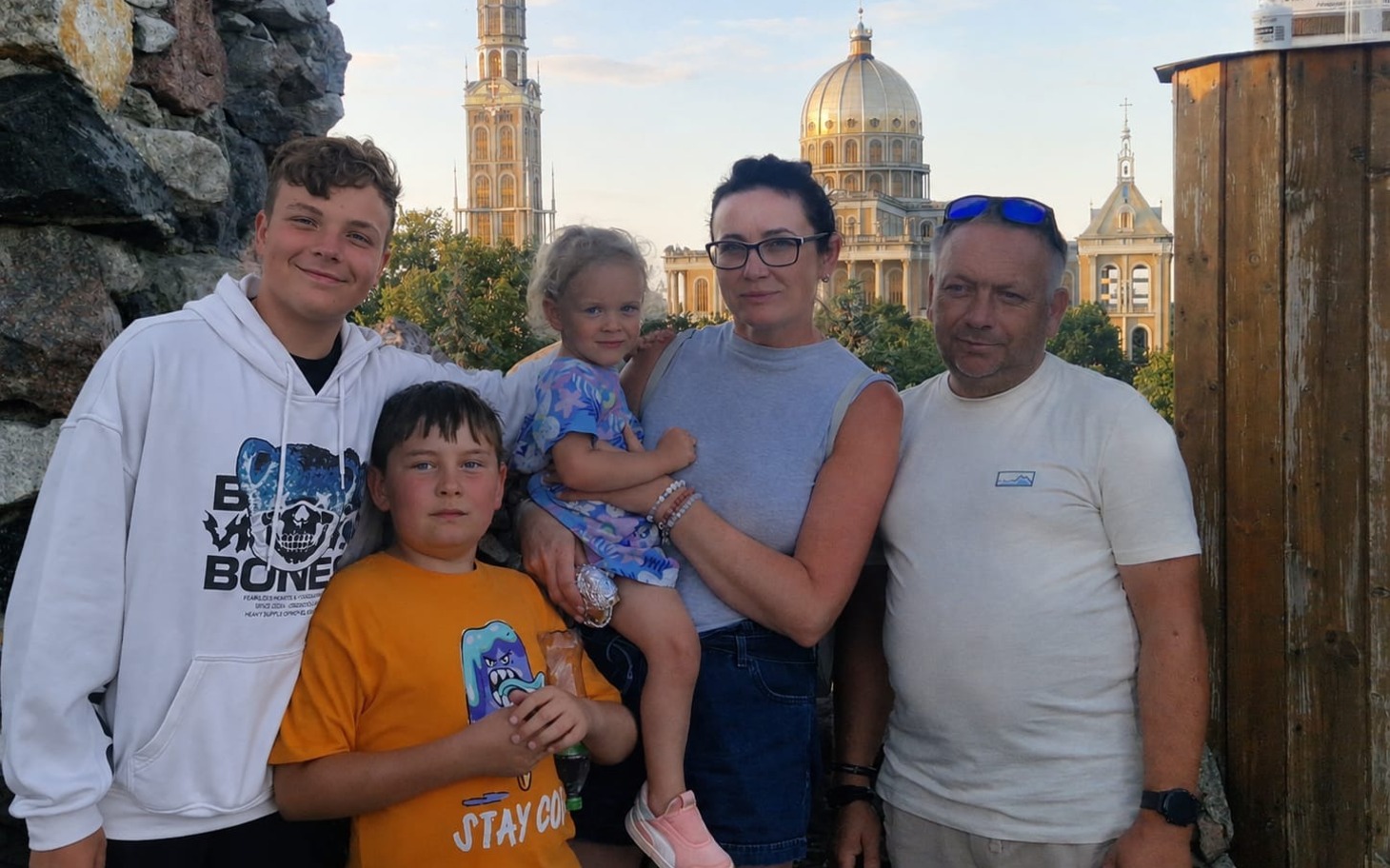 
        Rodzina na tle zabytkowej kopuły i dziedzińca, spontaniczne zdjęcie.
    