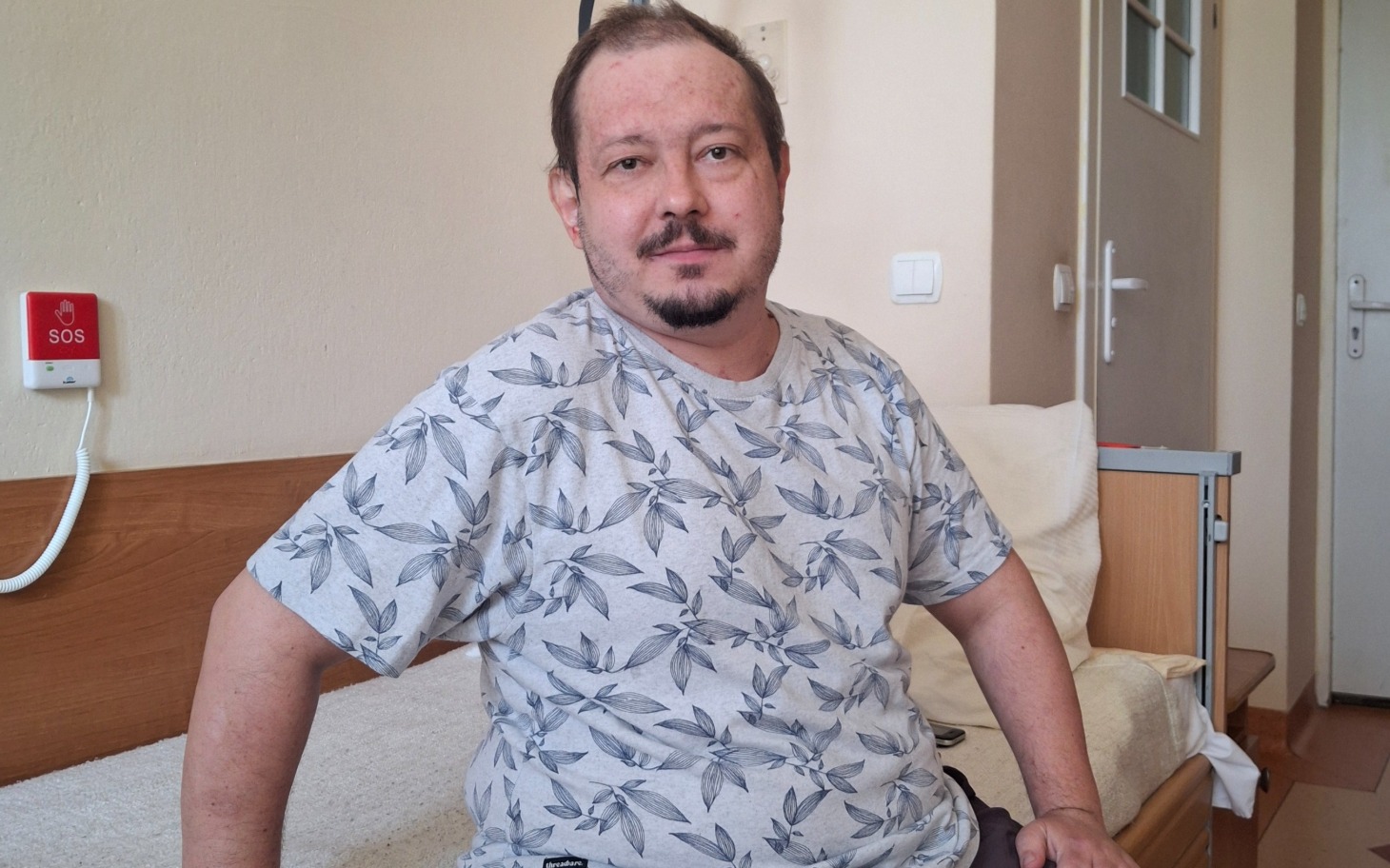
        Pies leżący na podłodze, widać balkon i zabudowę w tle.
    