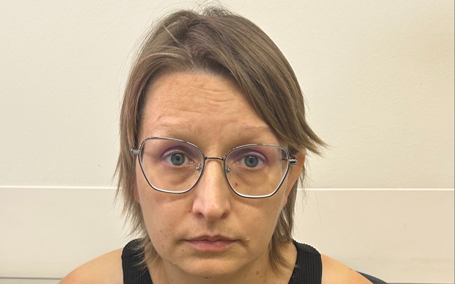 
        Osoba w okularach patrzy prosto przed siebie, z bliska portret.
    