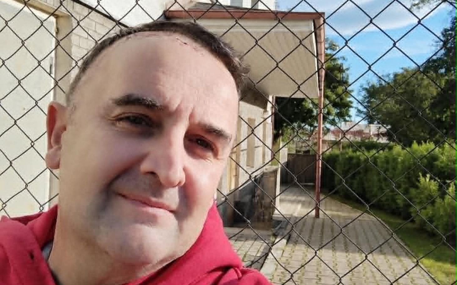 
        Pies w ramionach człowieka, uśmiech i radość.
    