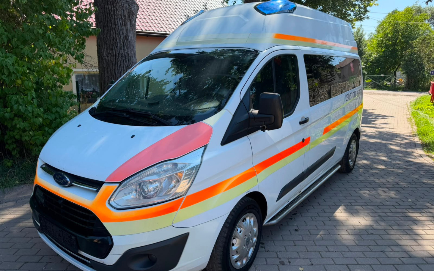 
        Ambulans medyczny na zewnątrz, jasne niebo.
    
