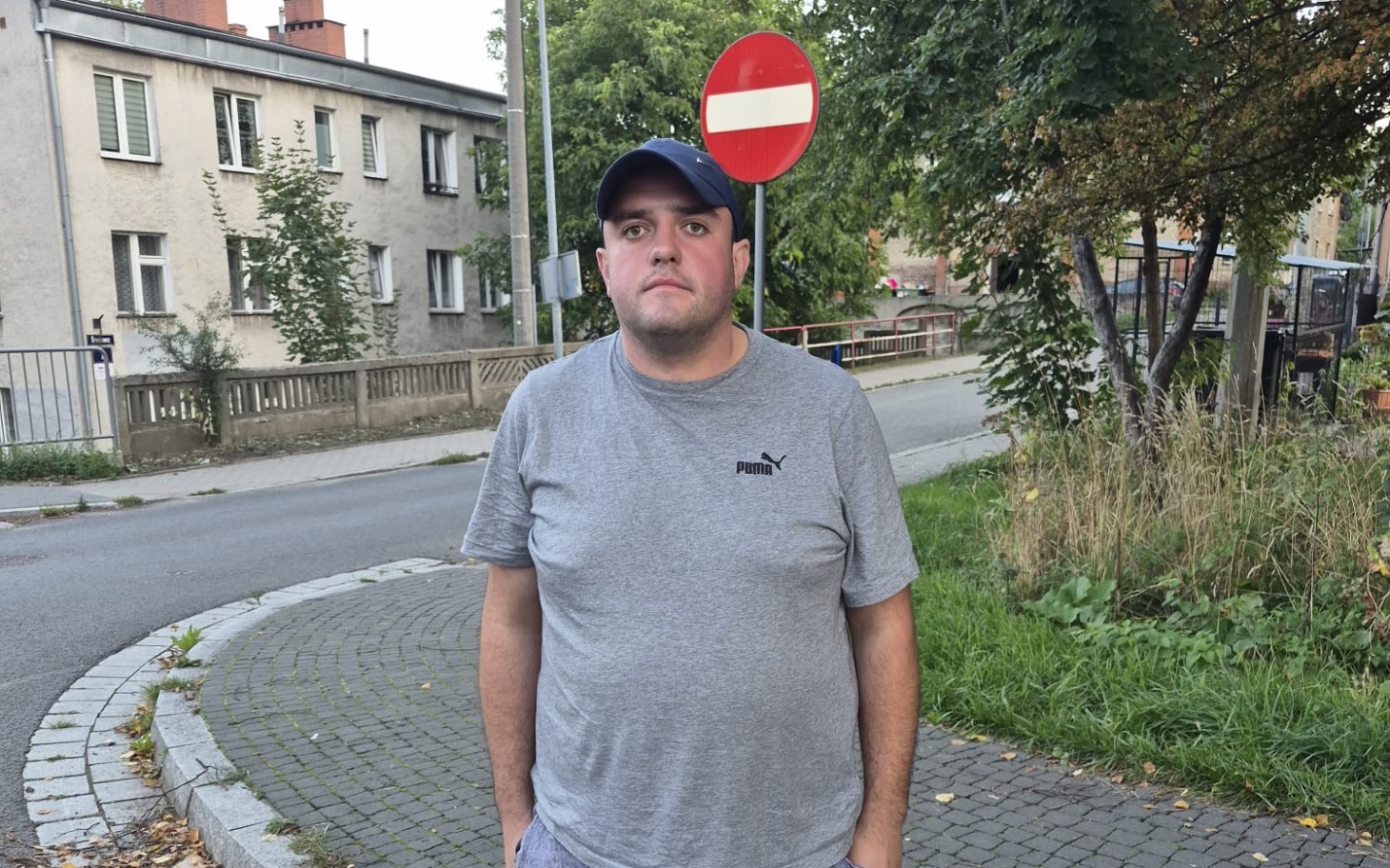 
        Mały kociak trzymany w rękach, ubrany w ochraniacz łapki
    