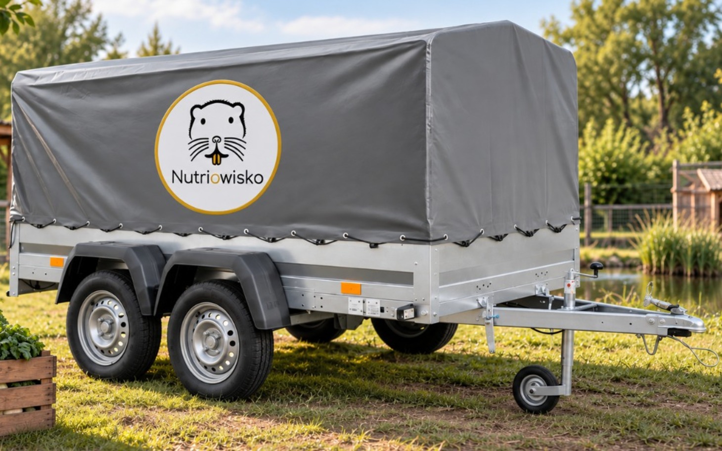 Przyczepa z plandeką na polanie, logo NutriWisko na bagażniku.
