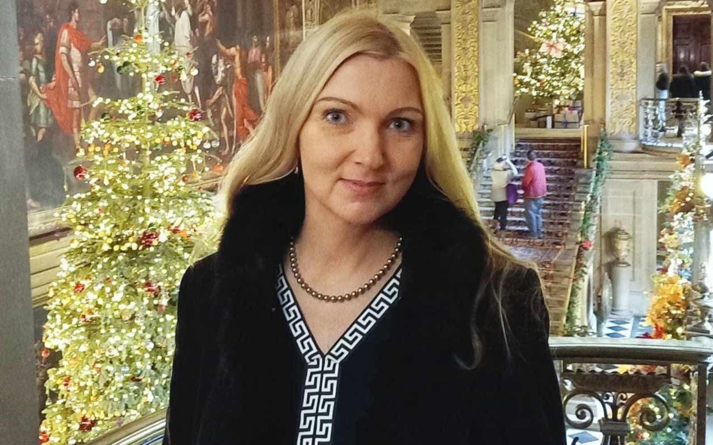 
        Elegancka dama w czarnej sukience pośród świątecznego wystroju
    