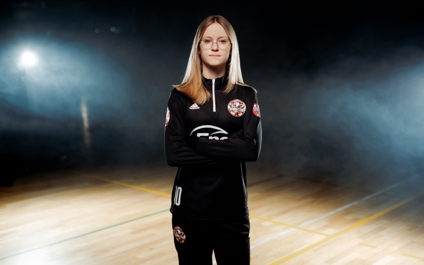 
        Młoda zawodniczka w czarnym stroju sportowym na boisku z planem do fotografii
    