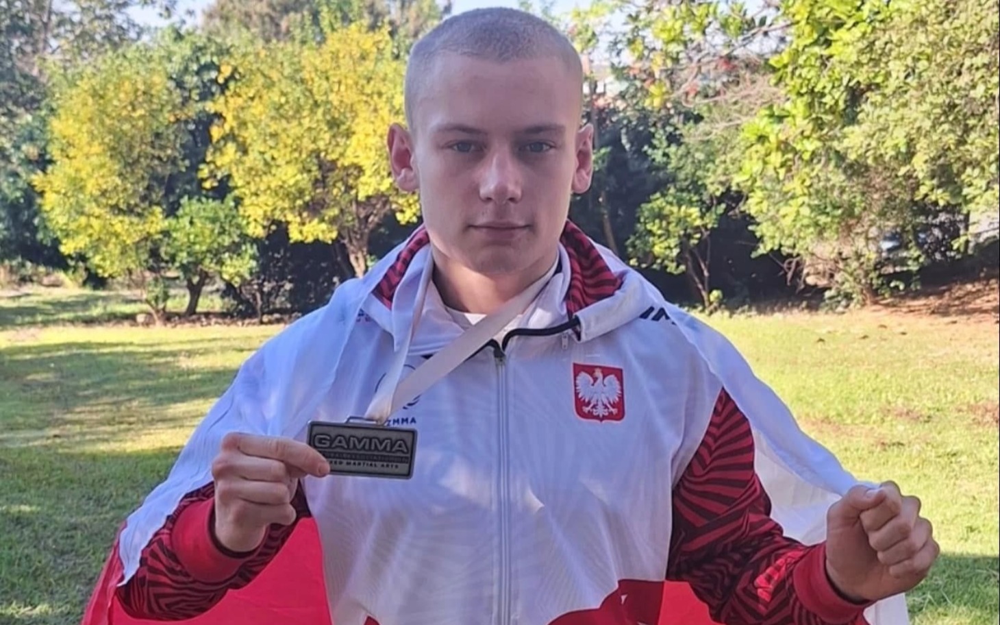 
        Dwa koty w kociarni, jeden czarny, drugi jasny, przytulają się.
    