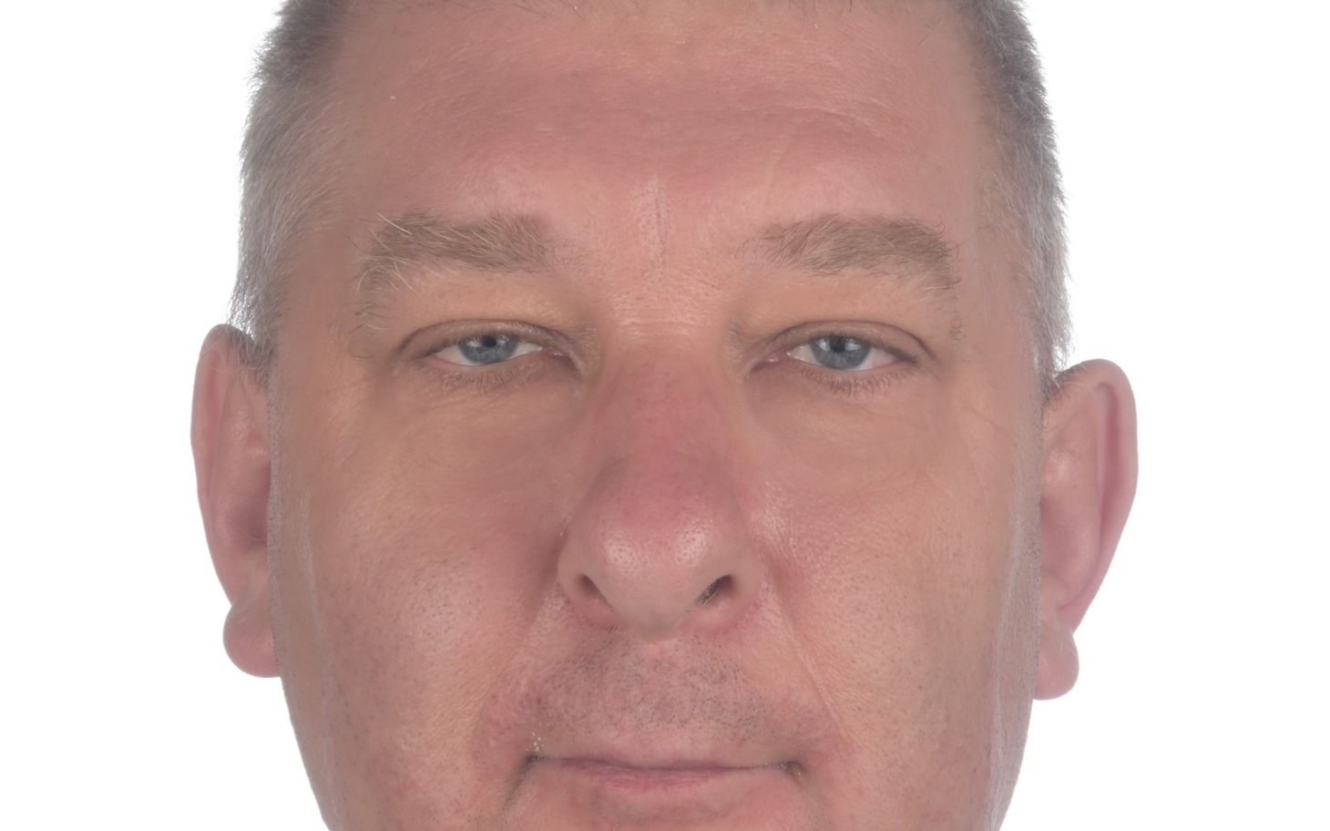 
        Mężczyzna z poważnym wyrazem twarzy, patrzący w obiektyw.
    