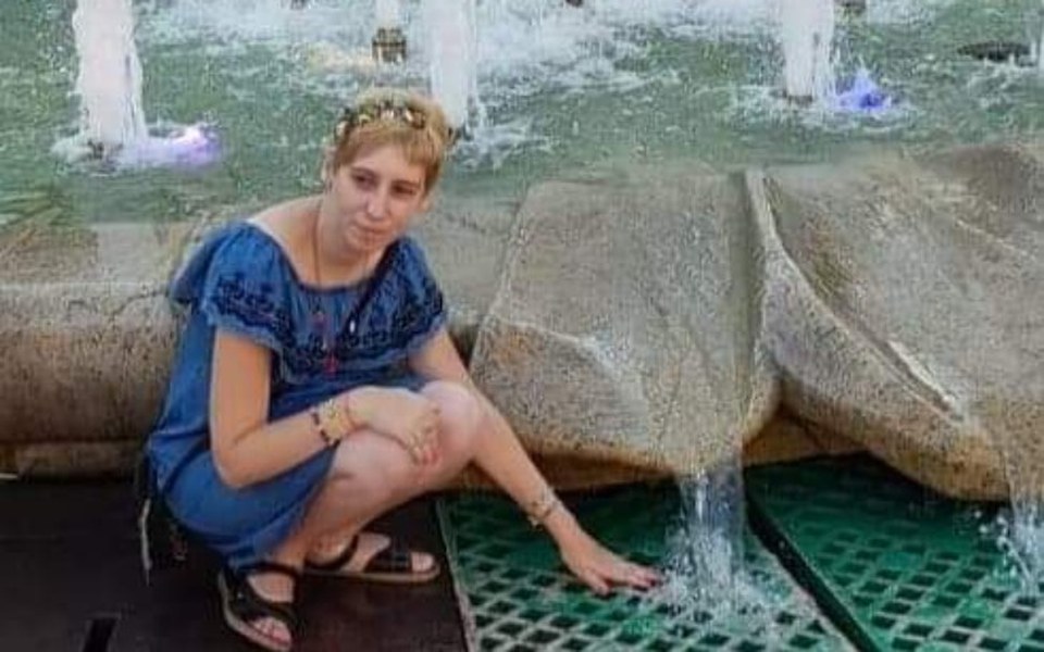 
        Kobieta przy fontannie, dotykająca wody.
    